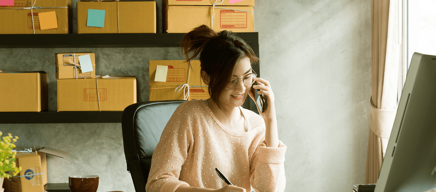 Mulher fala ao telefone em mesa de escritório